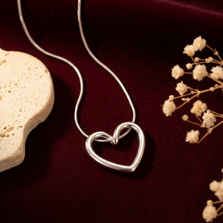 Silver hollow-heart necklace on burgundy velvet